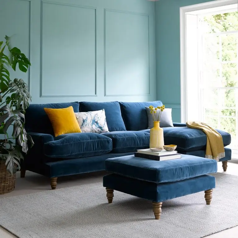 sala com sofá azul parede azul claro e amofada amarela